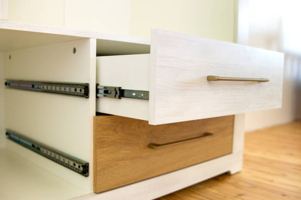 Close up of installation of wooden drawer in contemporary cupboard cabinet.